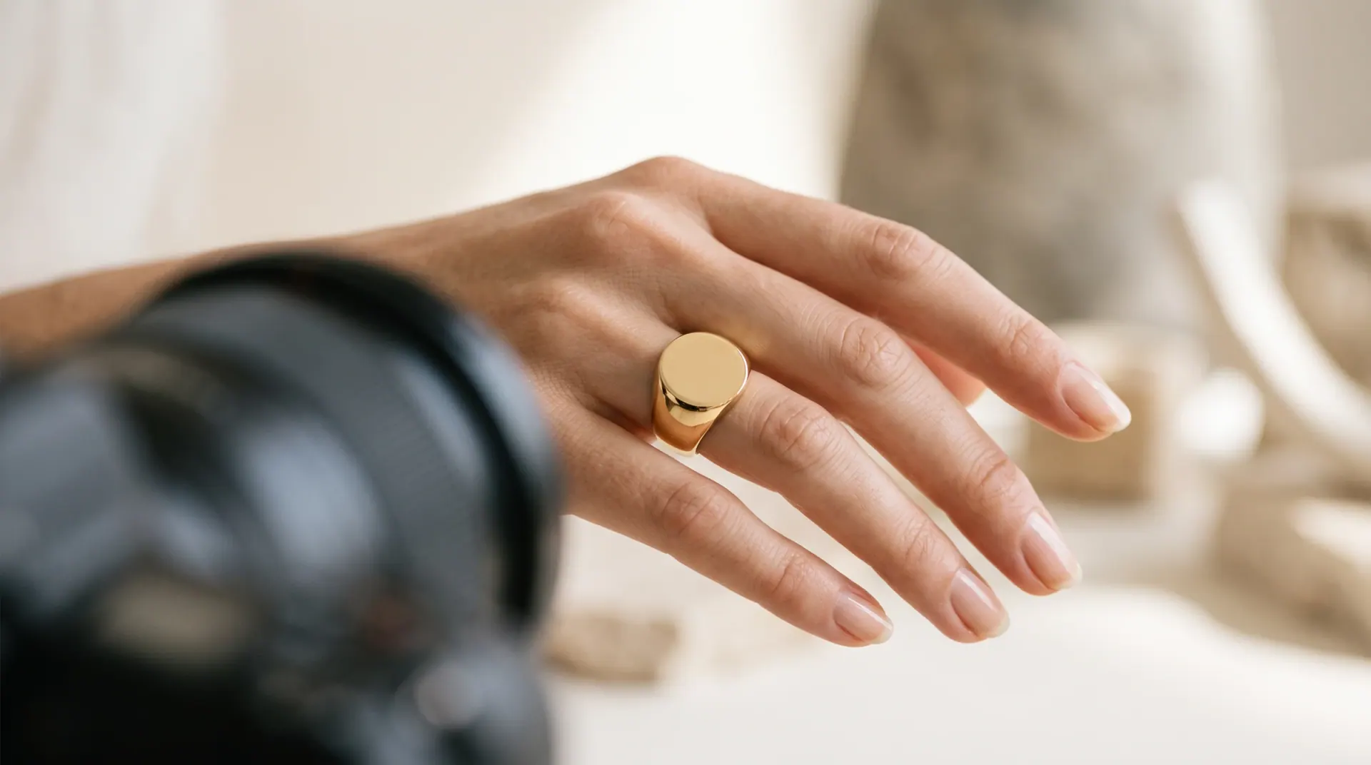 A hand model wearing a signet ring during a professional photoshoot.