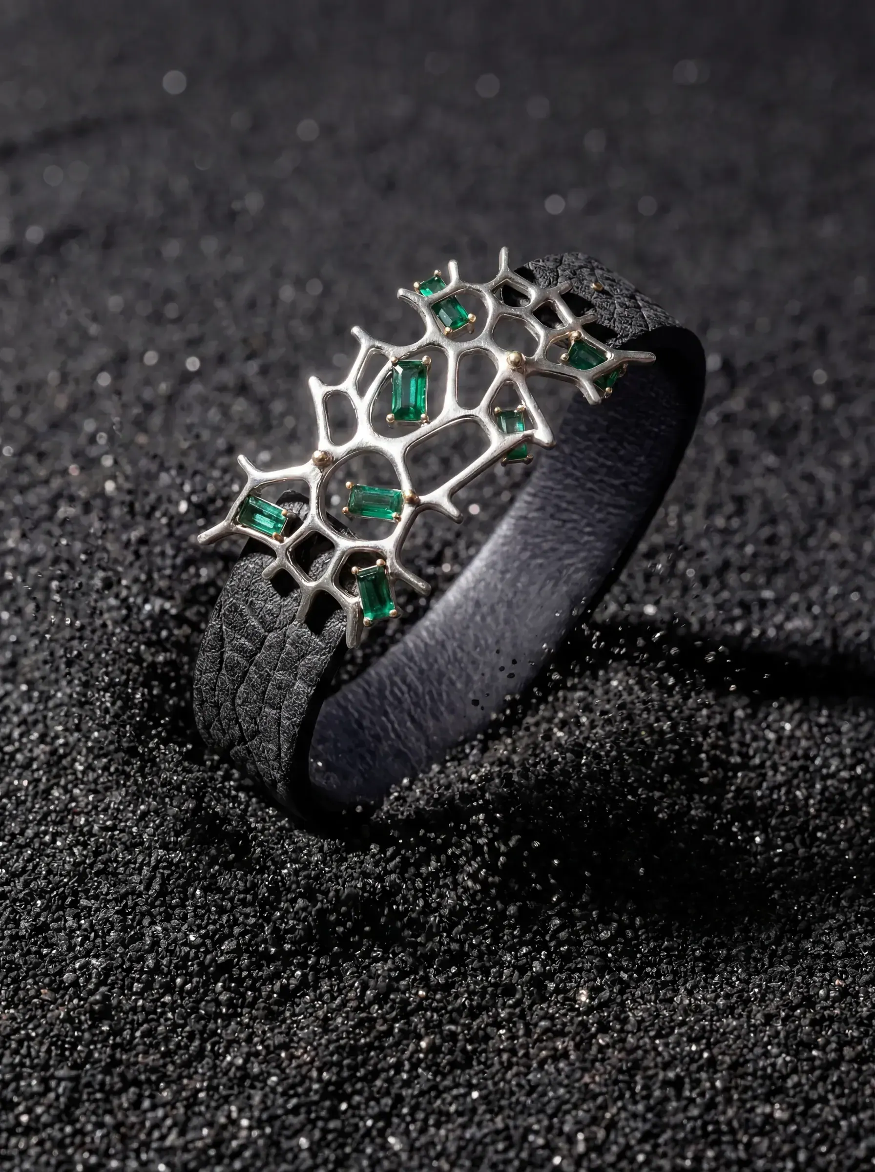 The gemstone cuff standing on dark sand