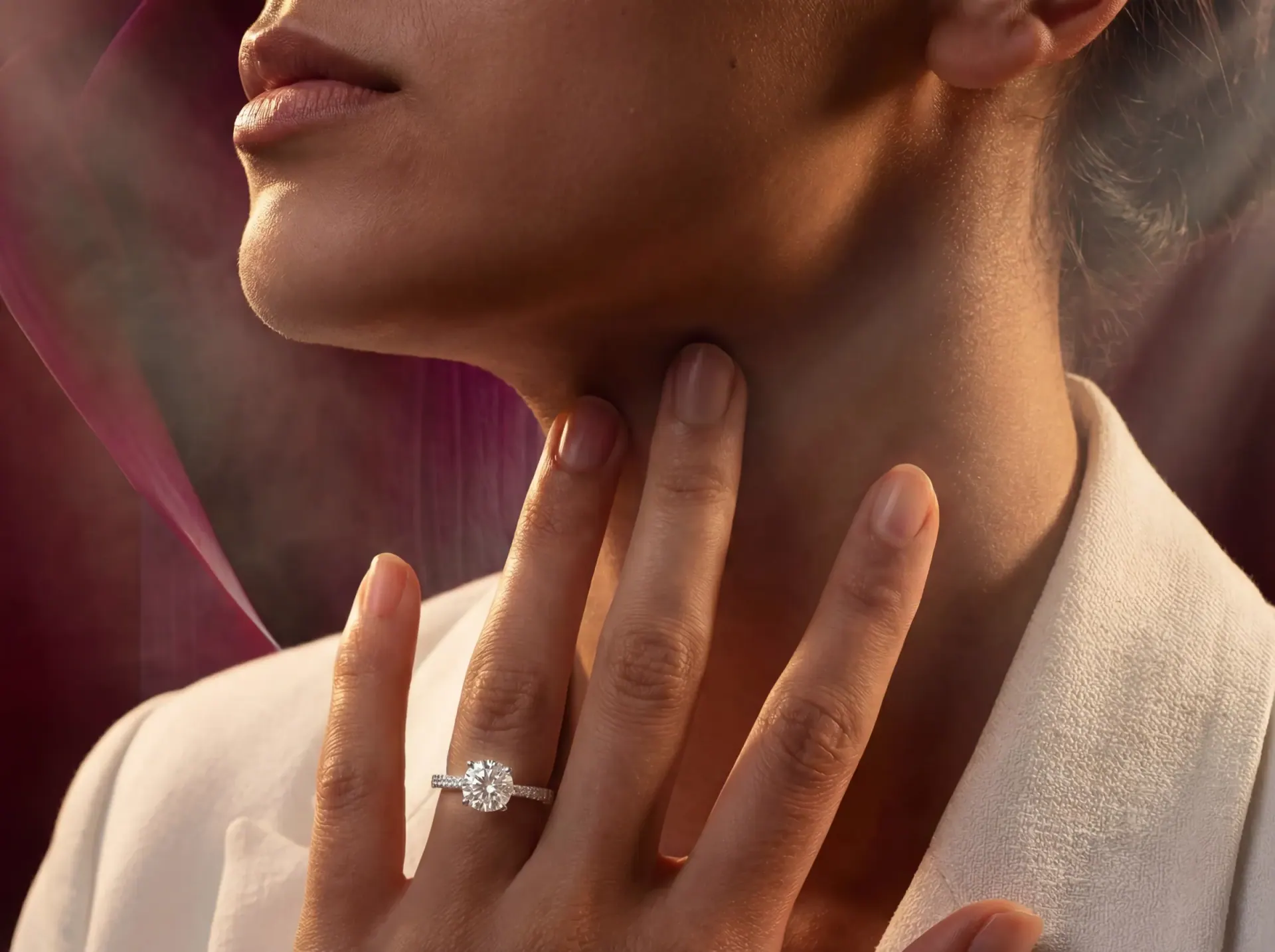 The solitaire ring worn, a hand resting at the neck